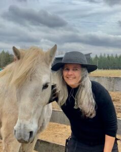 Tori smiling beside a horse